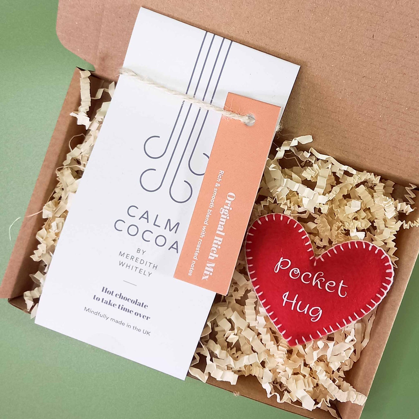 Gift box containing a vegan friendly felt pocket hug heart and a 2 serving sachet of vegan calm cocoa hot chocolate