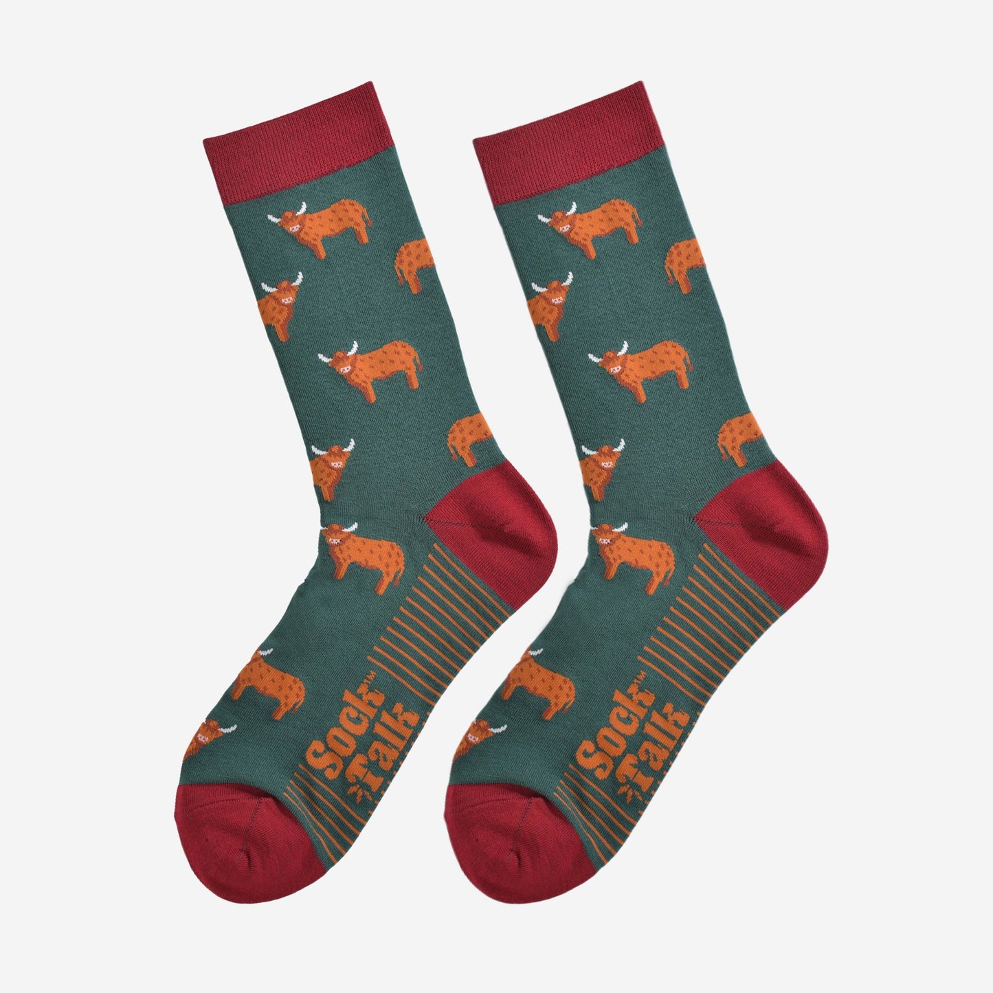 Green socks with red toes, heels and cuffs and images of highland cows