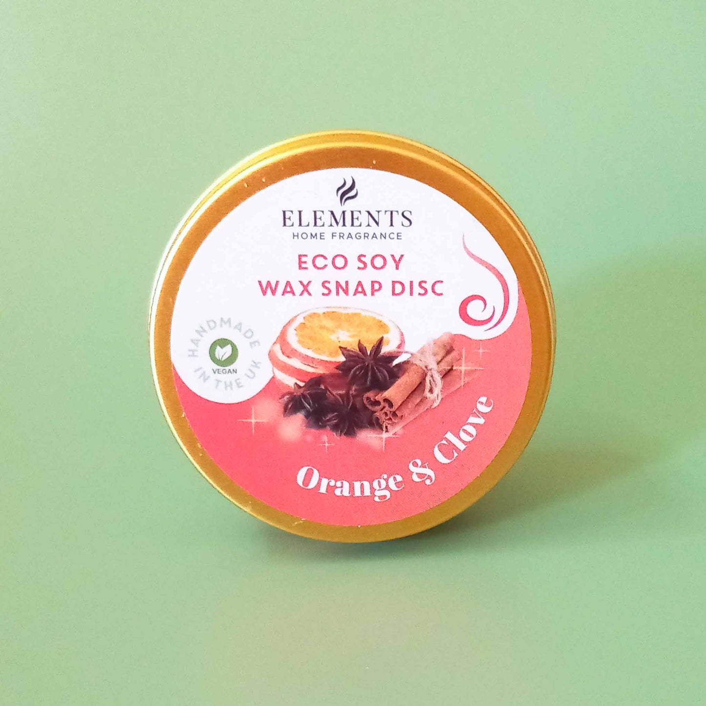 A round metal tin containing an orange and clove scented wax melt snap disc