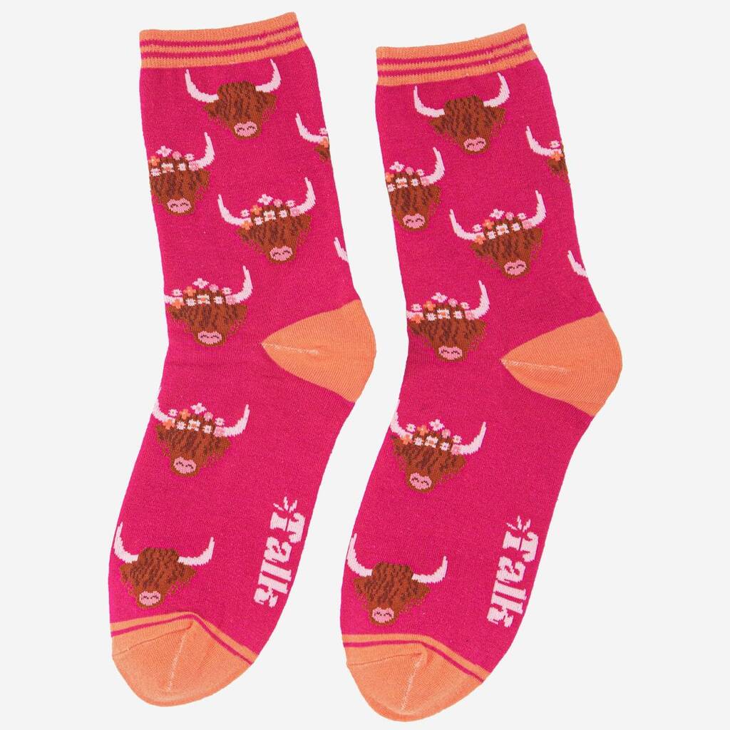 A pair of pink highland cow socks with orange toes, heels and cuffs