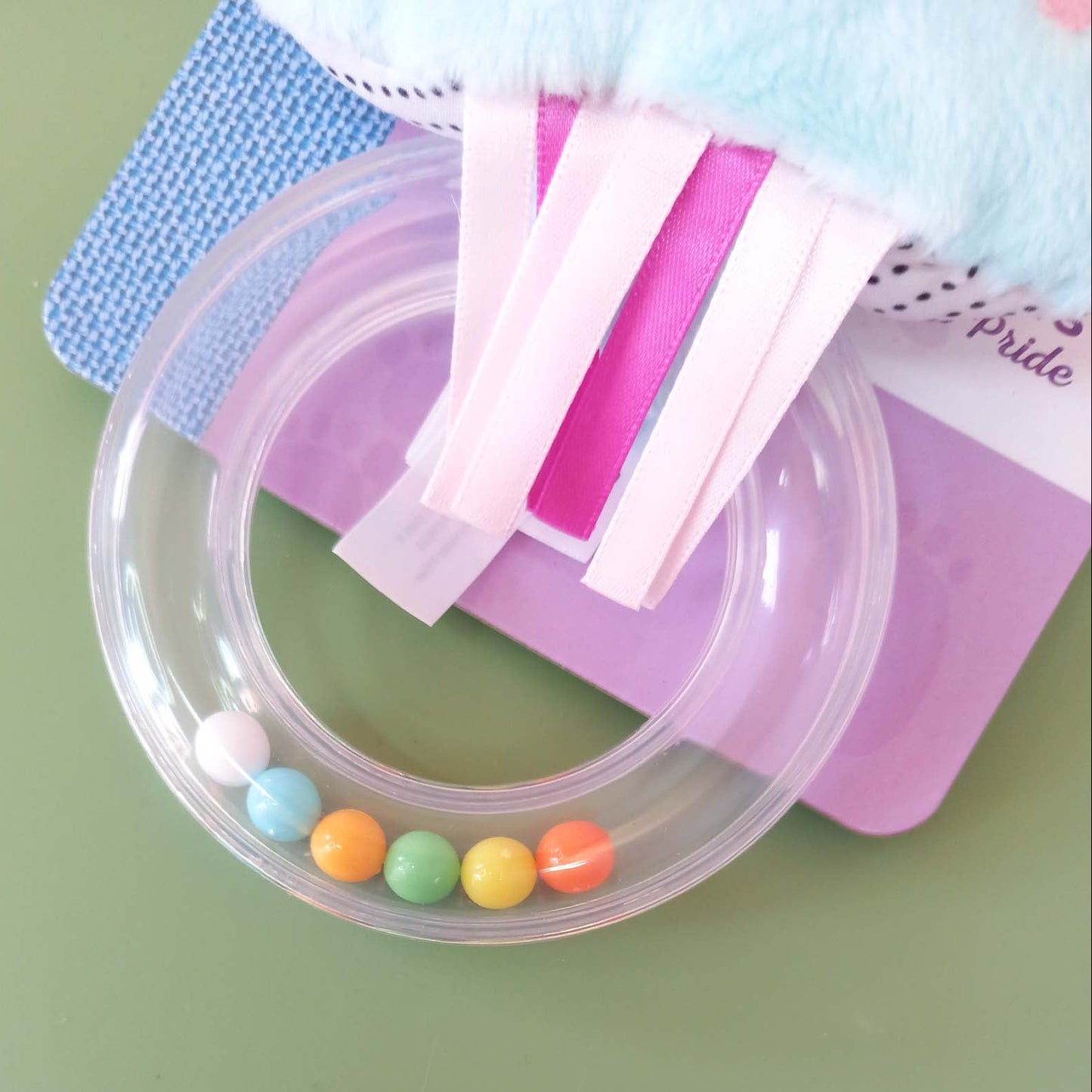 Close up of clear rattle handle containing colourful beads