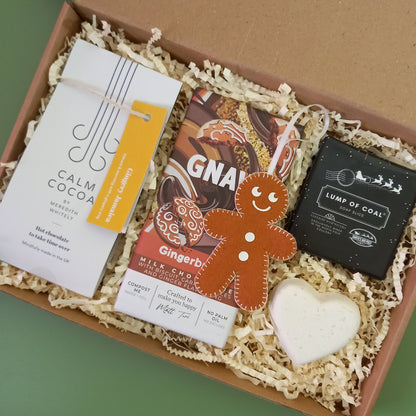A gingerbread themed Christmas gift box containing ginger hot chocolate, soap, bath bomb and chocolate bar