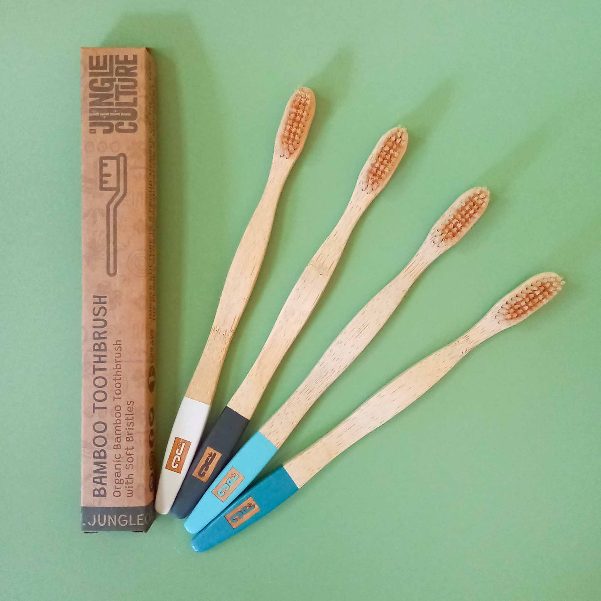 4 bamboo toothbrushes with various colour painted end of handles 