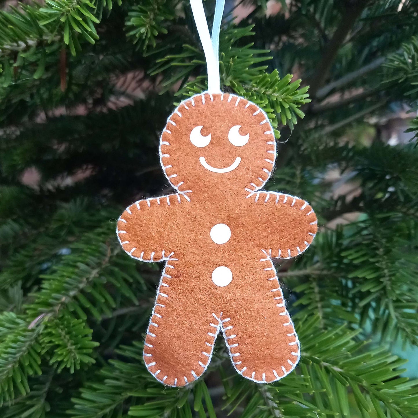 Felt gingerbread man tree decoration with a smiley face