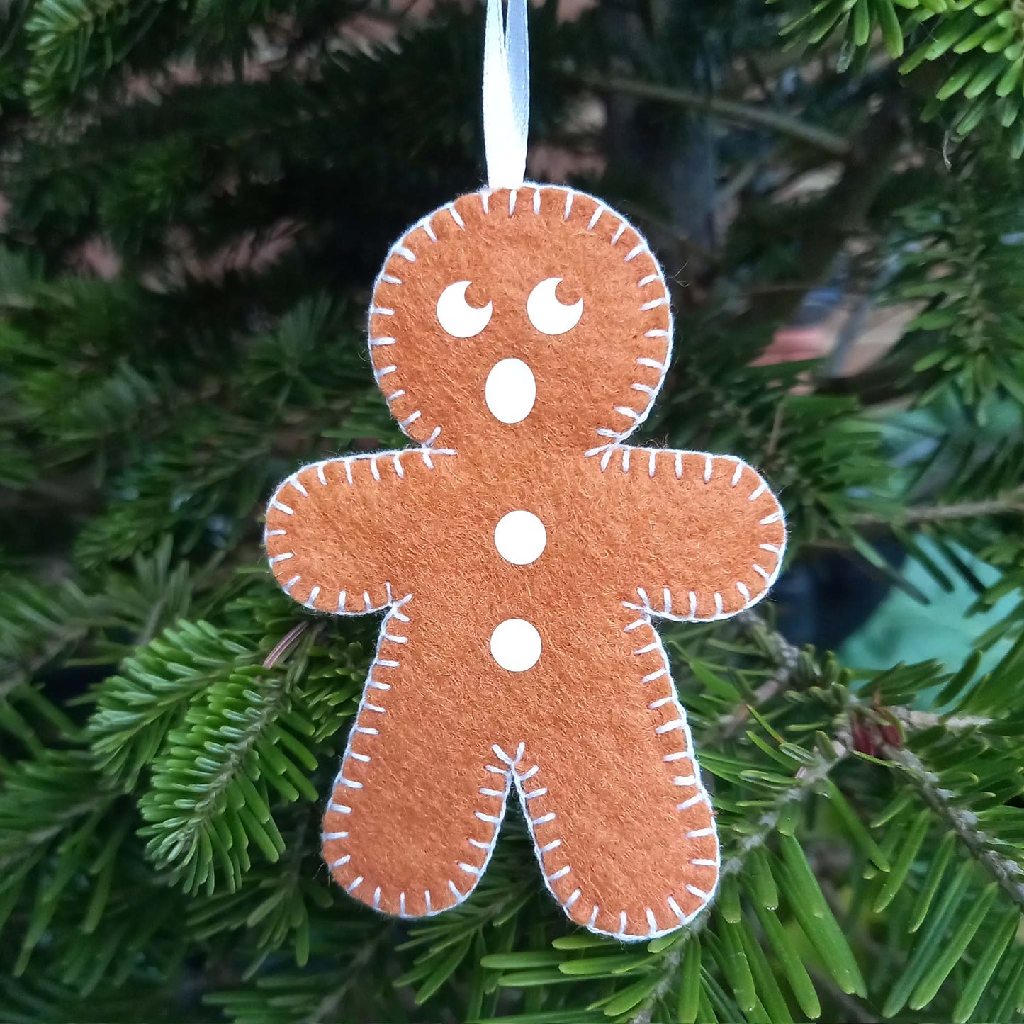 Felt gingerbread man tree decoration with a surprised face