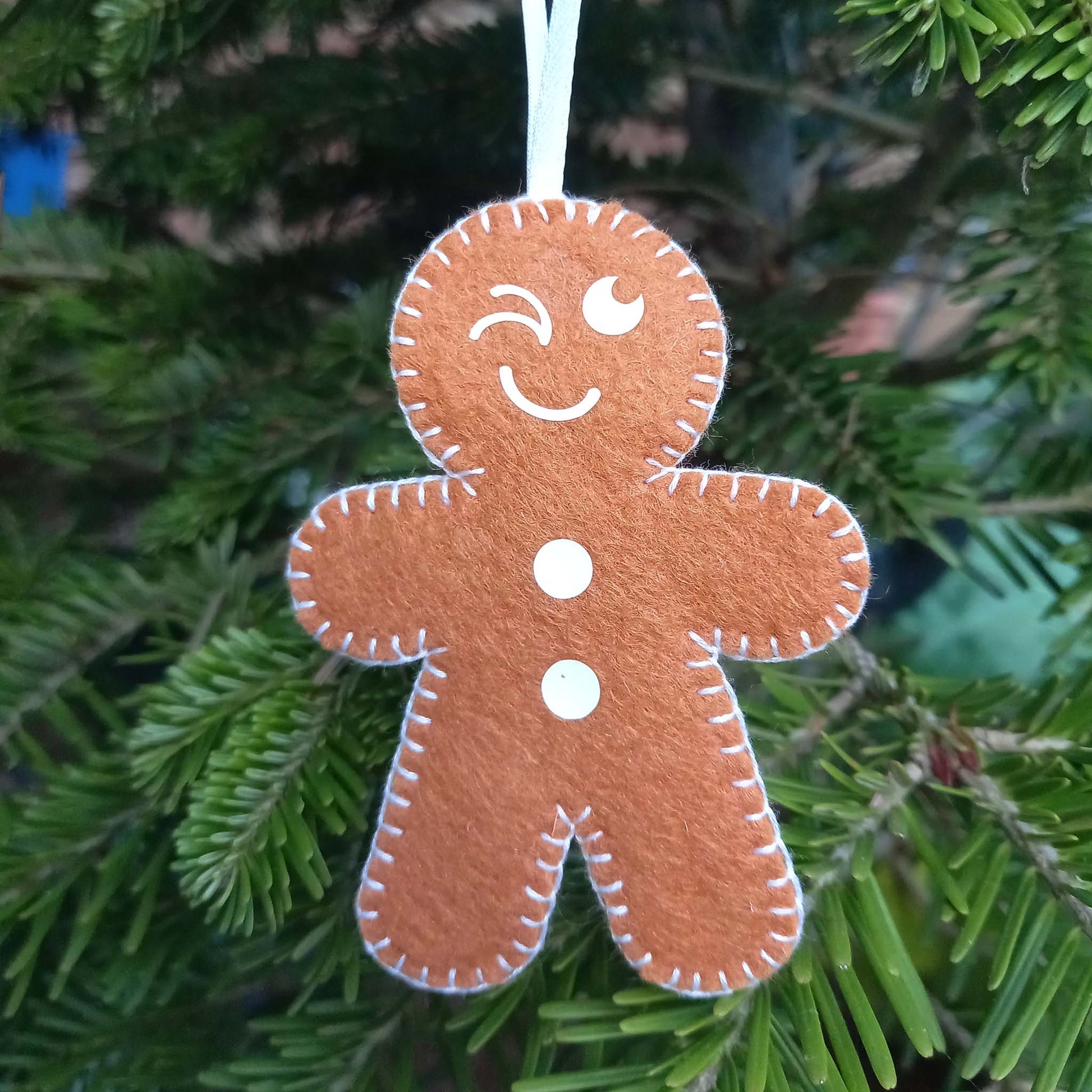 Felt gingerbread man tree decoration with a winky face