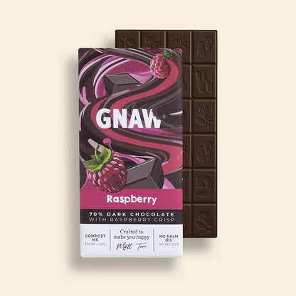 Dark chocolate bar with raspberry crisp and its packaging on a light beige background