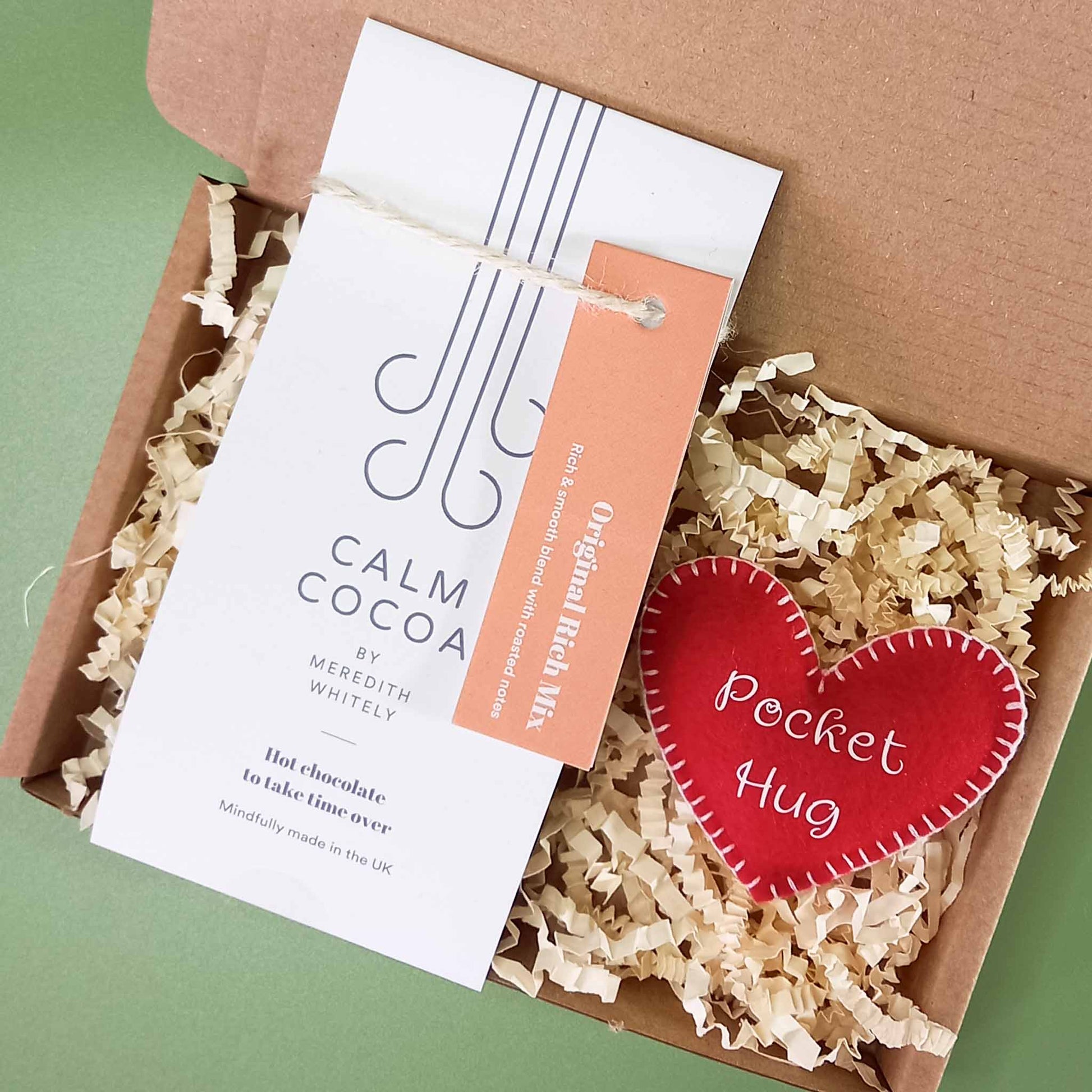 Gift box containing a vegan friendly felt pocket hug heart and a 2 serving sachet of vegan calm cocoa hot chocolate