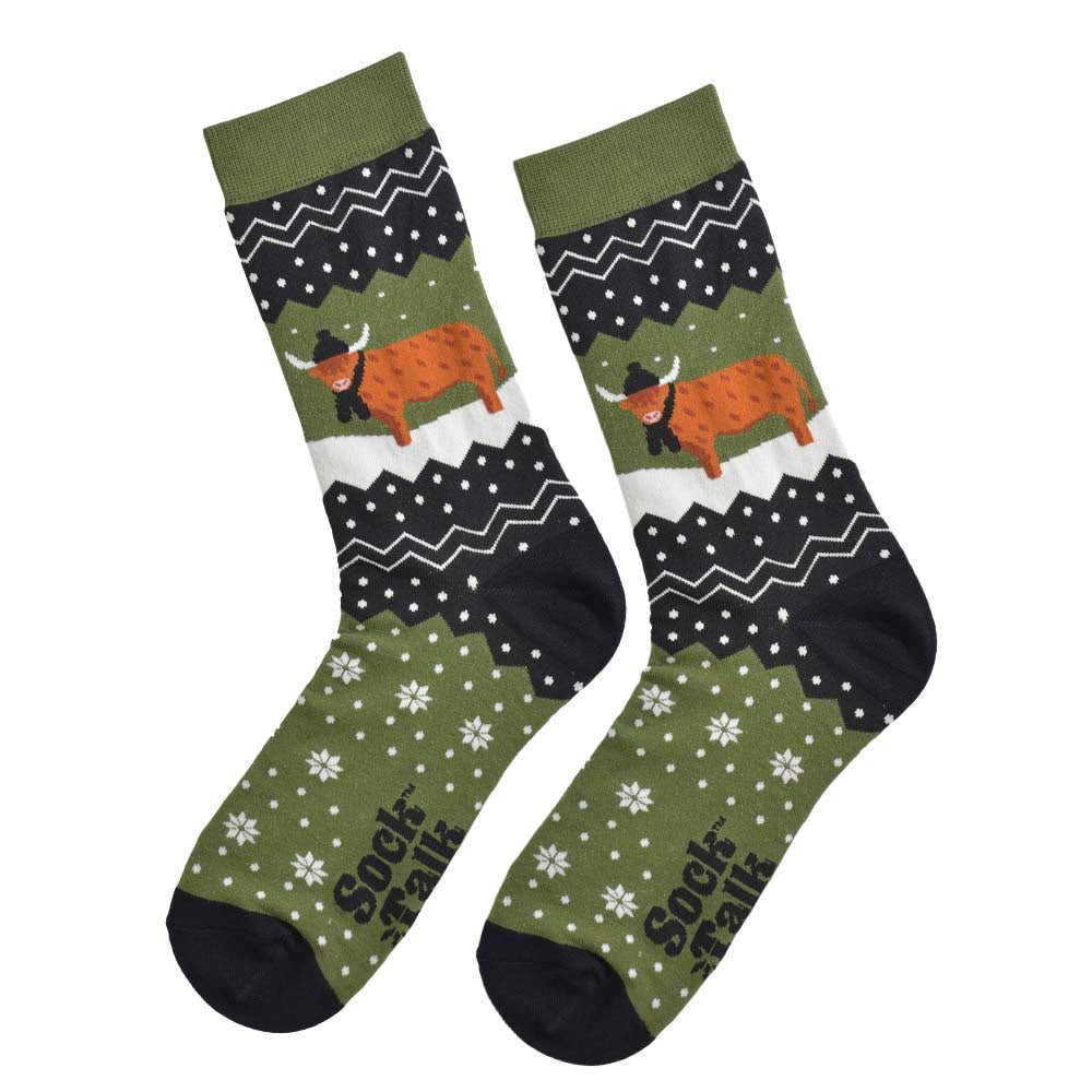 A pair of olive green and black socks featuring a winter themed highland cow wearing a hat and scarf