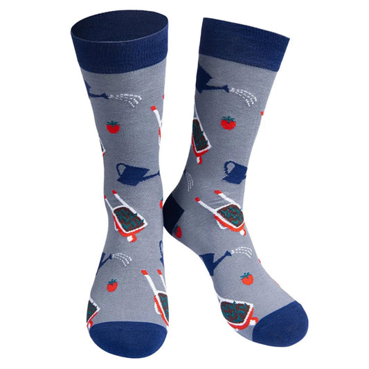 A pair of grey men's socks featuring wheelbarrows, water cans and tomatoes. With navy blue toes, heels and cuffs