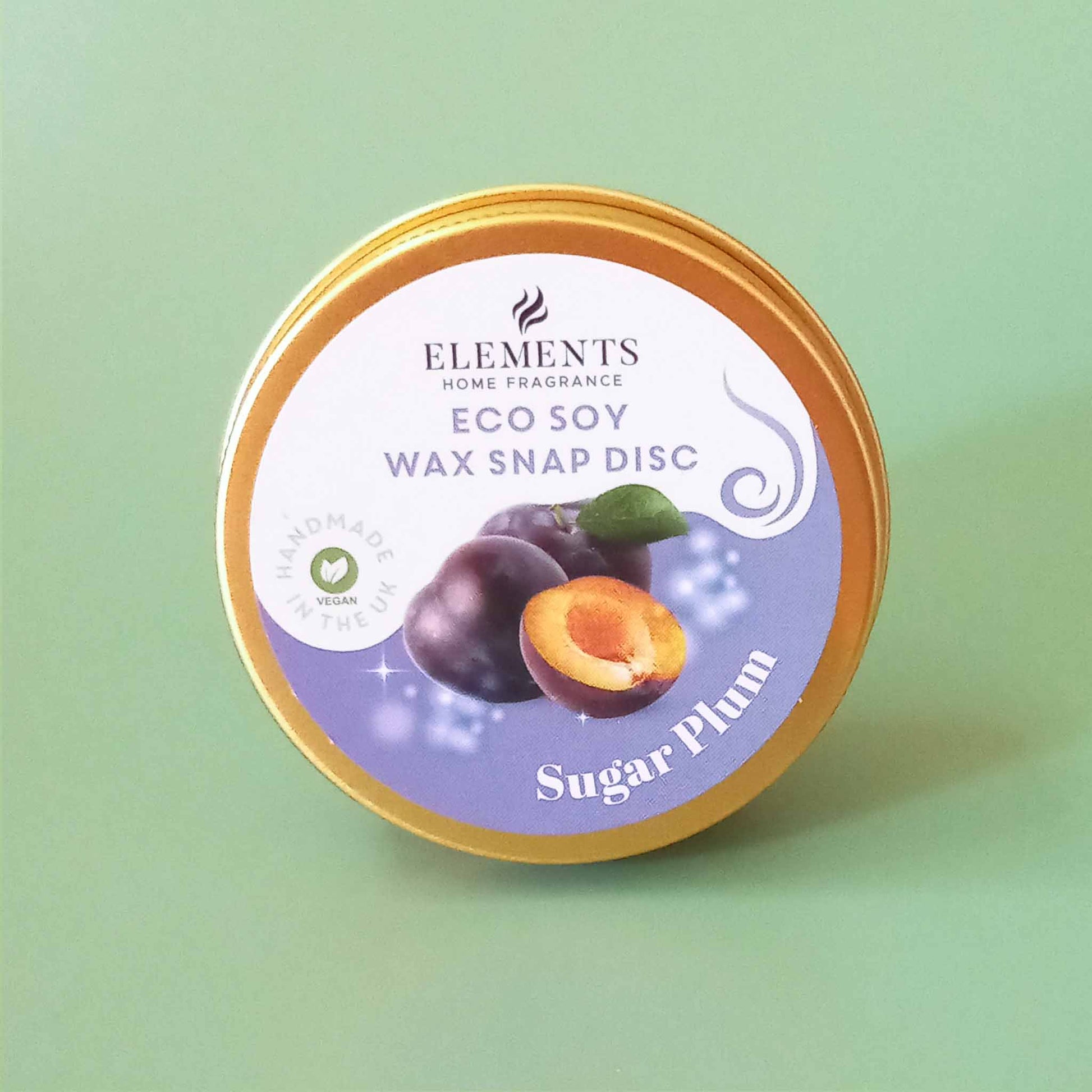 A round metal tin containing a sugar plum scented wax melt snap disc