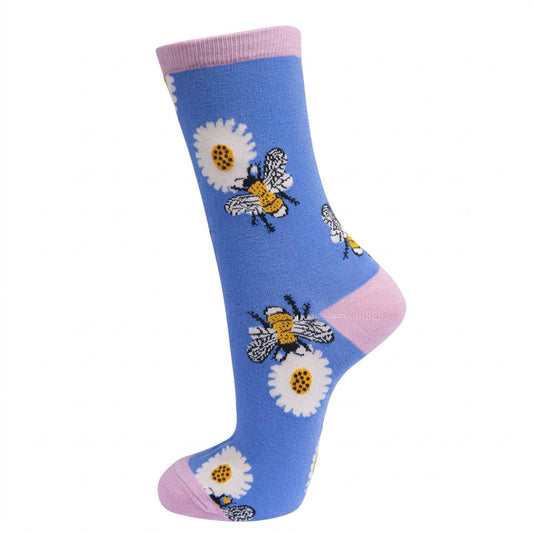 A single blue crew sock with pink cuffs and heels, decorated with white daisies and yellow-and-black bumblebees, shown on a plain white background.