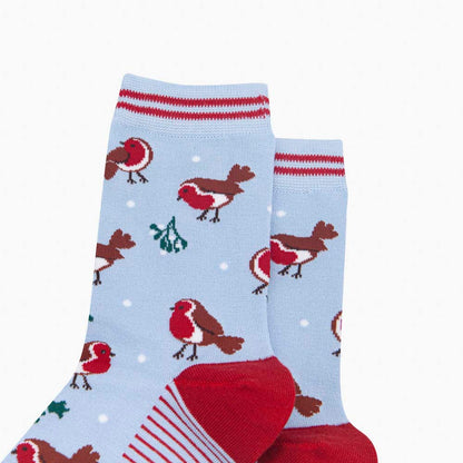 Close-up of light blue Christmas socks depicting robins, holly and mistletoe with red heels and cuffs