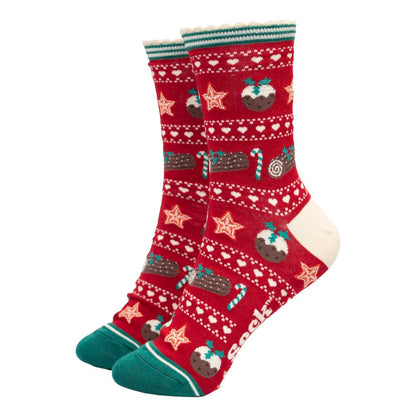 A pair of red women's socks with cream heels and green toes featuring a Christmas pudding, yule log, candy cane and gingerbread star design in a Fair Isle style layout
