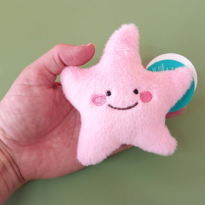 Hand holding pink starfish soft toy